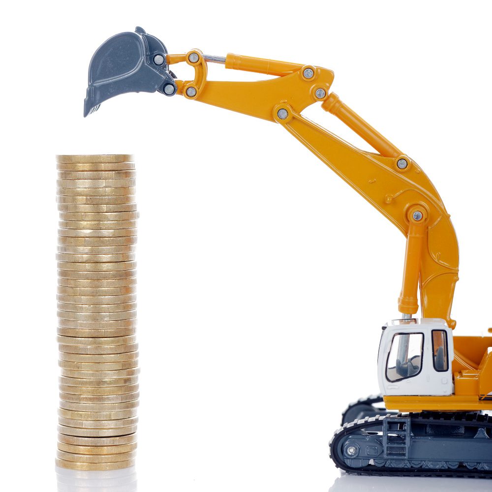 Toy excavator beside a stack of coins